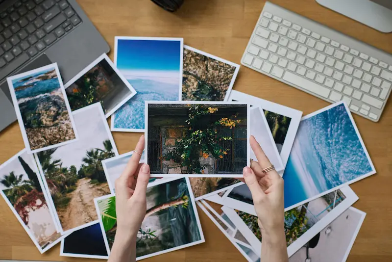 Pile of photos on the phone with a view of person's hands sorting them